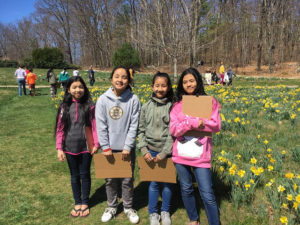 Four children pose for a photo next to the daffodil field