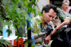 A tattoo artist gives a tattoo in the conservatory during an event