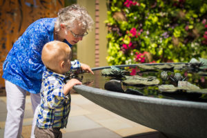 A visitor and a child look into the water feature of The Court.
