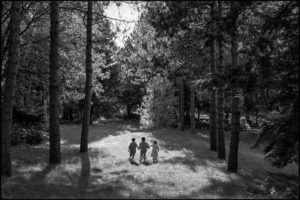 Black and white photo of Cousins walk hand in hand though the woods.