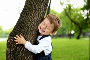 A child hugging a tree.