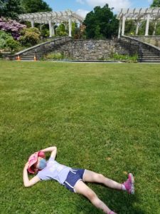 a child lays In the grass in the secret garden