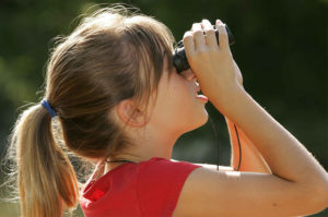 A child looks through binoculars.