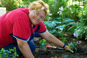 A young girl from Girls Inc volunteers her time at the Garden.