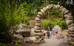 A family plays in the rock building area of the Ramble.