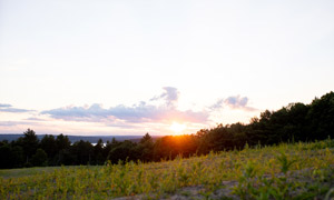 The sun sets over the northwestern meadow and reservoir.