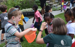 Kids from the HeadStart program play with butterfly nets in the Secret Garden.