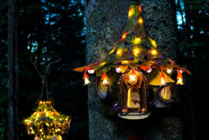 Mini fairy houses with leaf roofs lit up at night