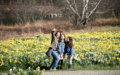 A family takes a selfie in front of the daffodil field