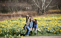 A mother and her two daughters pose for a photo in front of the Field of Daffodils.