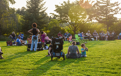 Visitors sit and listen to music during an outdoor concert in the Lawn Garden.