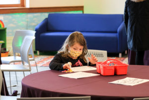 A young girl draws at a table during February Vacation week.