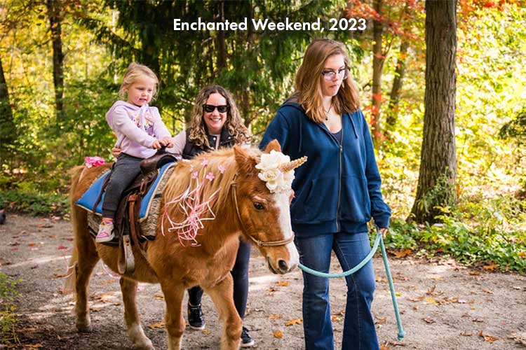 A young child on a pony ride during Enchanted Weekend.