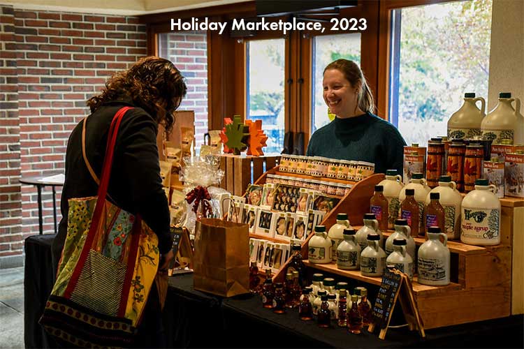 A visitor stops at a vendor booth during the Holiday Marketplace.