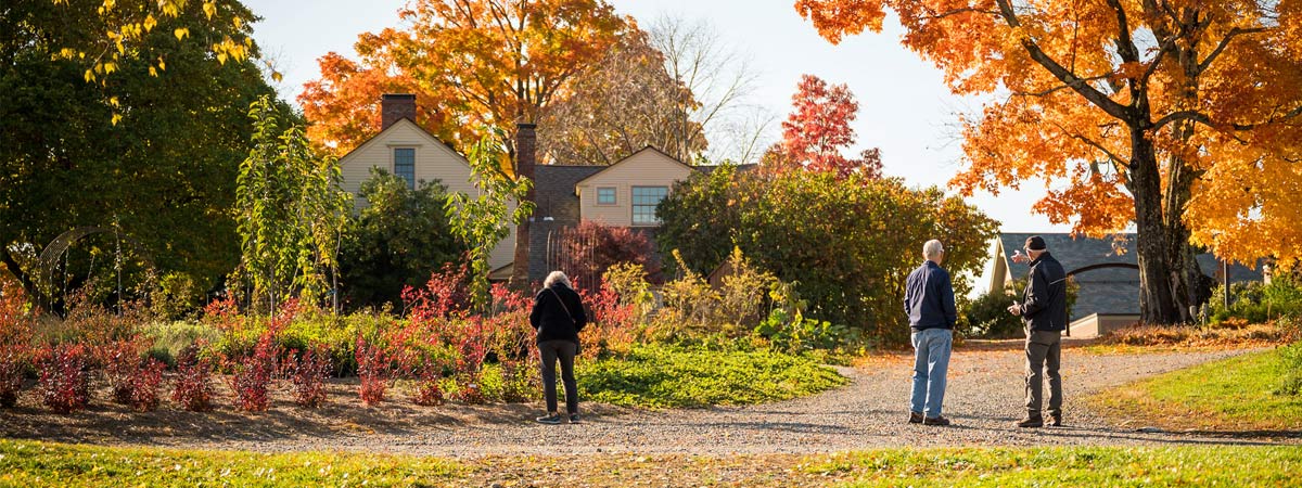 Visitors walking up the the Vegetable Garden surrounded by fall foliage.
