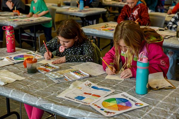 Two girls work on a painting activity during april vacation week.