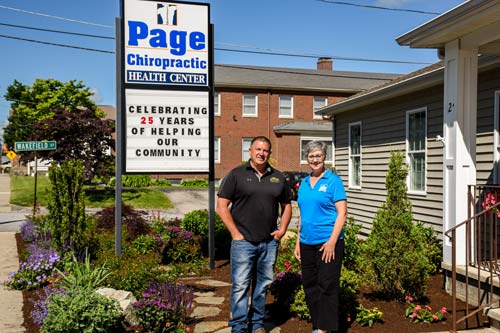 Page Chiropractic stand outside with their sign.