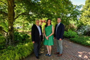 Two members of the Garden's senior leadership stand beside a member of the Board of Trustees