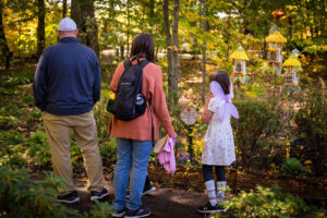 A family looks at the fairy houses scattered about The Ramble