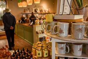 Display of merchandises within the garden's shop including mugs, honey, and books.