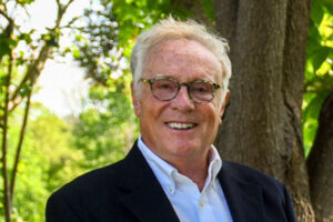 Kent Russell smiling in a suit outdoor