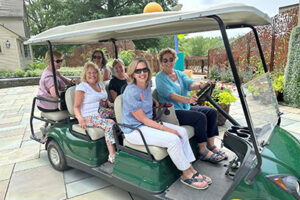 Sally Stanton and her crew smiling in a golf cart