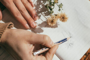 Set of hands planting flowers deep in ground full of soil