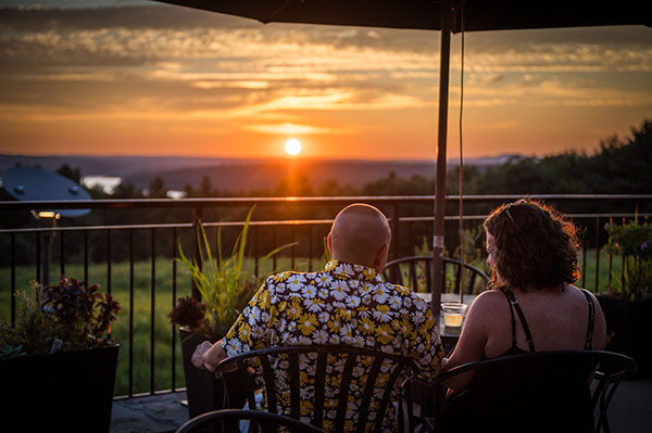 A couple looking out at the sunset from the cafe's balcony