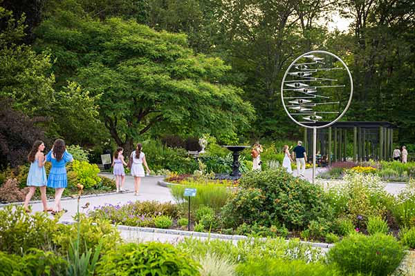Visitors walking among the Nadeau Garden with a stainless steel kinetic sculpture on display from the Art In Motion exhibit
