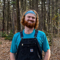 Hunter Blanchard, a Horticulturalist II at the Garden smiles in the Shade Garden