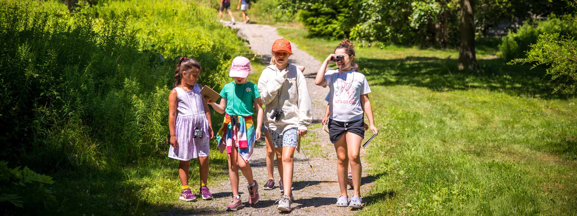 4 children attending Summer camp and walking a trail at New England Botanic Garden