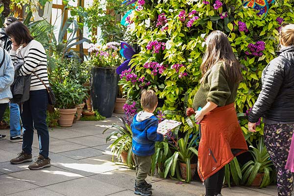 An instructor and youth student observing a bromeliad tree in the conservatory