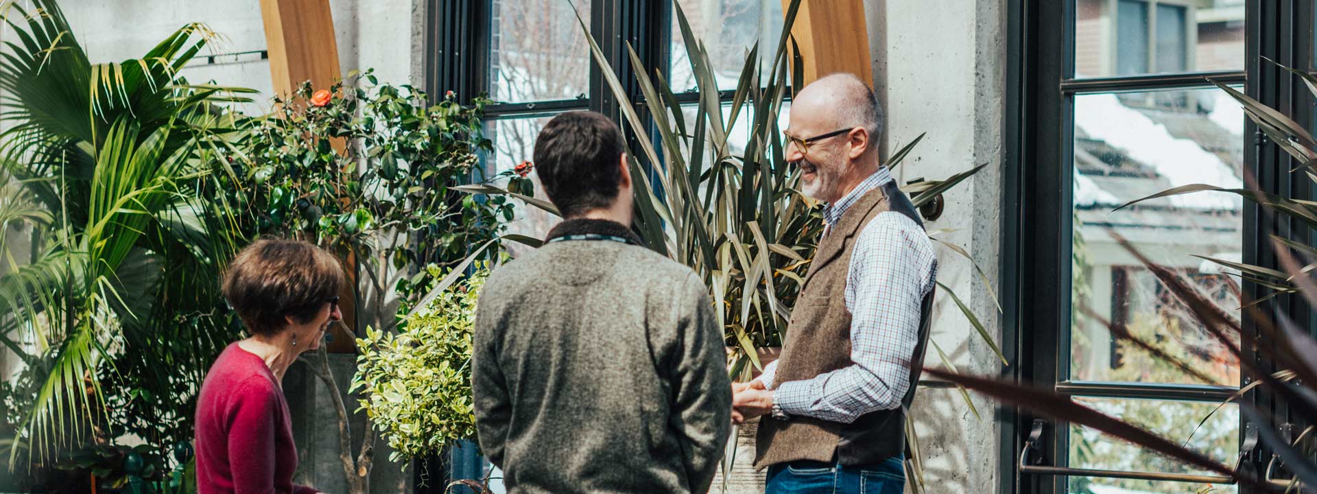 A guest speaker having a conversation with visitors in the conservatory