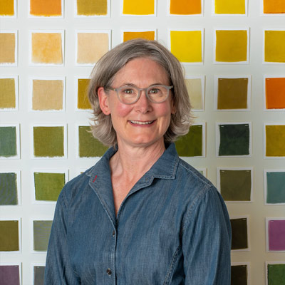 Julie Beeler standing in front of a grid color palette
