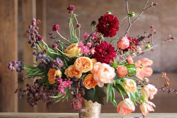 Colorful assortment of flowers arranged in a small gold plated vase