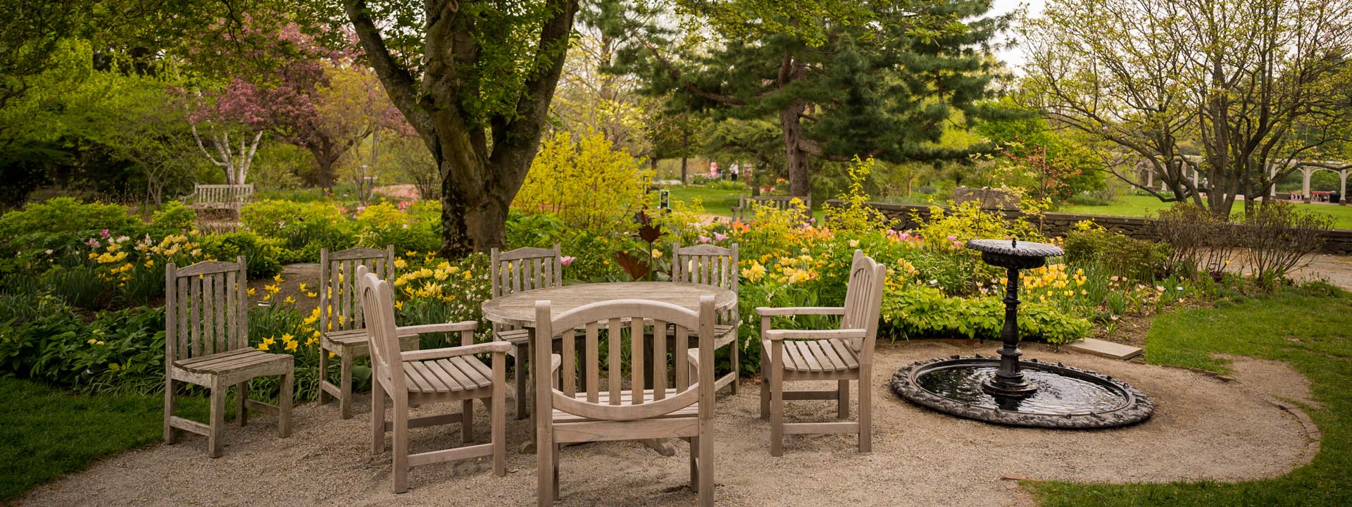 Outdoor wood chairs and table set up near the cottage garden near the Farm house during the springtime