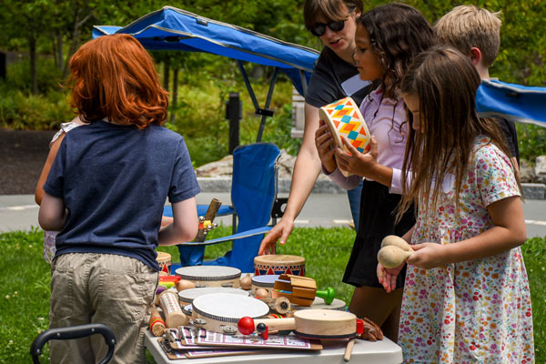 Kids playing with instruments outside on the lawn