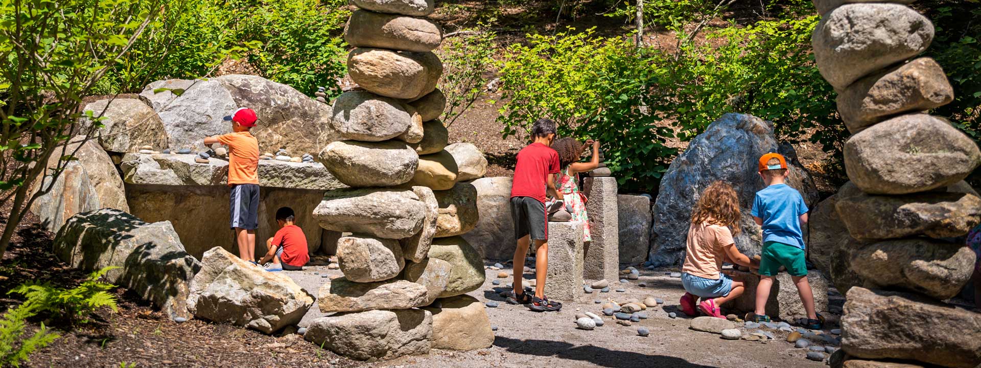 Kids stacking rocks during the summer in the Ramble garden