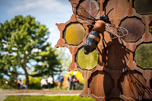 A larger-than-life glass sculpture of a bee sculpture and honey hive