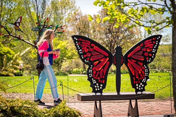 A larger-than-life steel and glass sculpture of an orange monarch butterfly