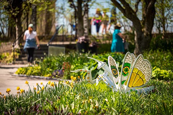 A larger-than-life steel and glass sculpture of a white praying mantis