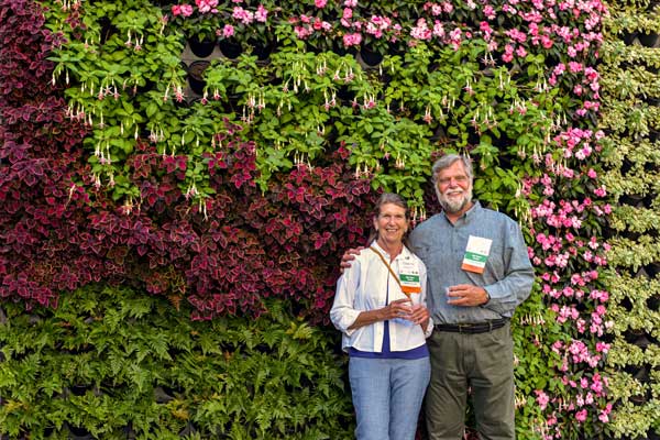 Visitors smiling in front of the living wall