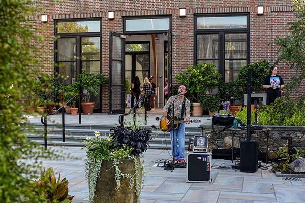 A musician performer singing and playing guitar at New England Botanic Garden