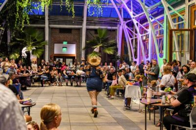 A drag queen putting on a show with an audience in the conservatory
