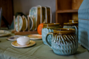 Ceramic mugs and plates for sale on a vendor's table