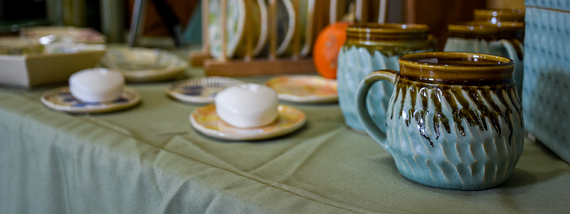 Ceramic mugs and plates for sale on a vendor's table